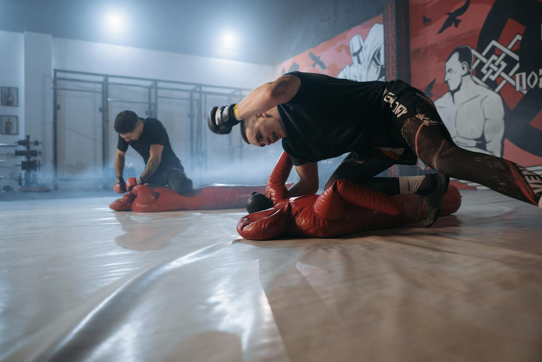 man in black t shirt and red pants doing push up