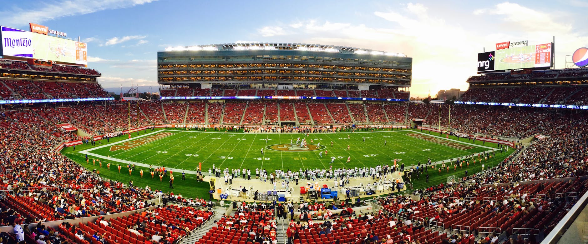 nfl stadium field full with crowd watching the game during daytime